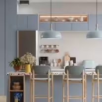 Pale blue upper cabinets over white bases with teal pendants and brass legged stools
